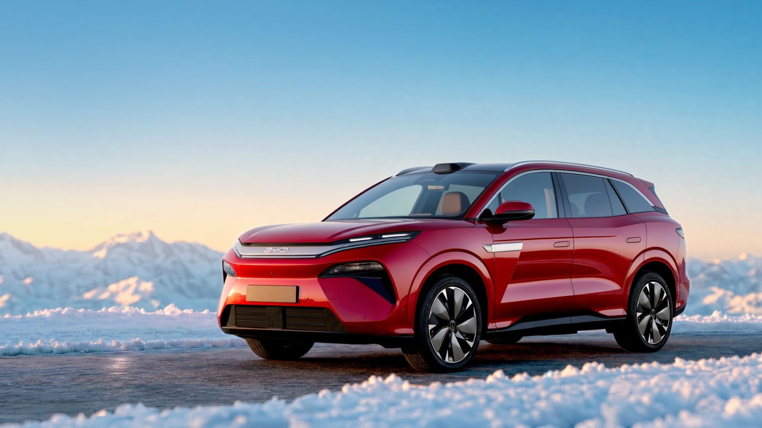 BYD Atto 8 hétüléses elektromos SUV piros színben, havas tájon