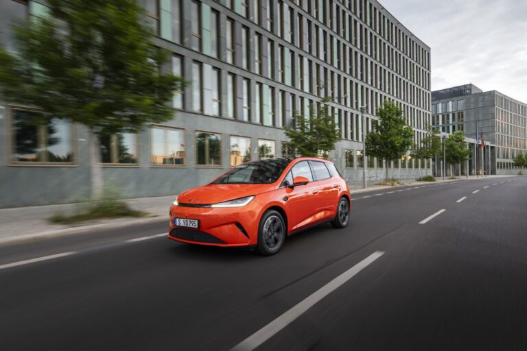 BYD Dolphin G DM-i narancssárga színben, városi úton