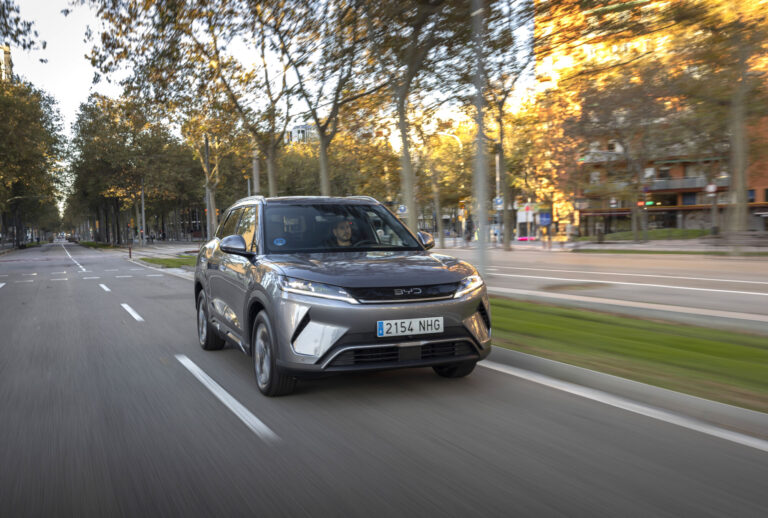 BYD regeneratív fékezés: szürke BYD Atto 2 városi sugárúton, őszi fák között